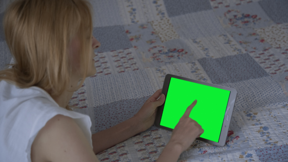 Beautiful Girl Using Tablet PC with Pre-keyed Green Screen Lying on Bed at Home 3