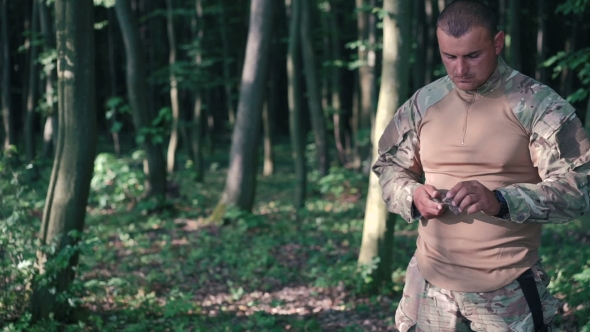 Military Sharpen Knife With Bilestone In The Forest. 