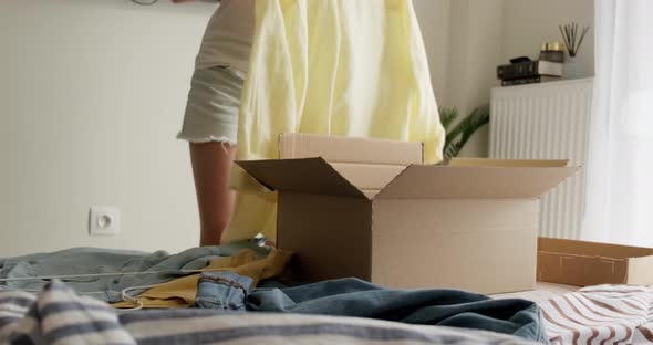 Woman packing used clothes into box to resell on the internet