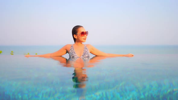 Young asian woman enjoy around outdoor swimming pool for leisure