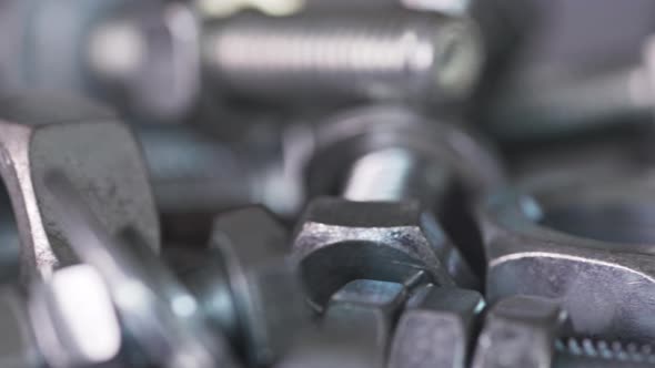 Slider Shot Video of Chrome Bolts and Nuts in a Chaotic Order Industrial Background