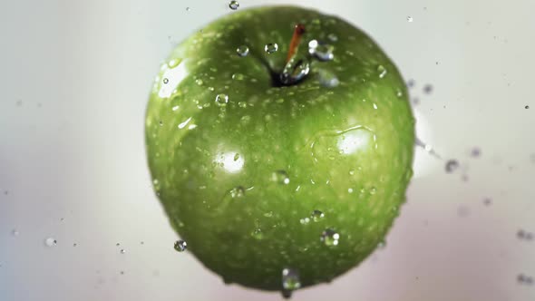 Flying of Green Apple in White Kitchen Background in Slow Motion