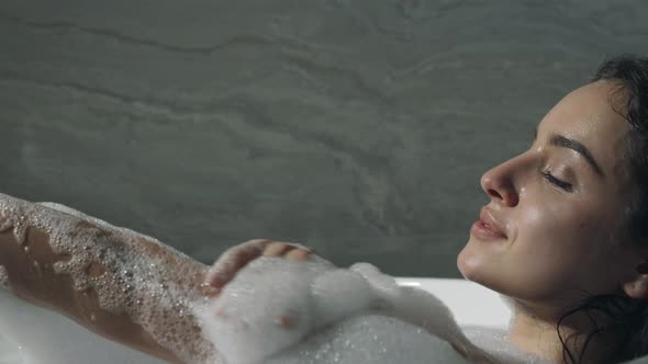 Relaxed Girl Resting in Bath. Hot Woman Washing Hands in Bathtub.