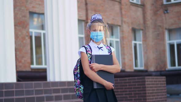 Outdoors Portrait of Schoolgirl, Teenage Girl, in Medical Mask and Protective Face Shield, with