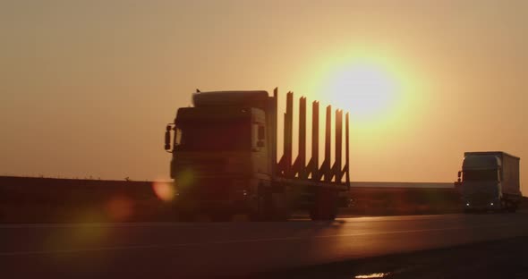 Trucks Moving On The Road At Sunset