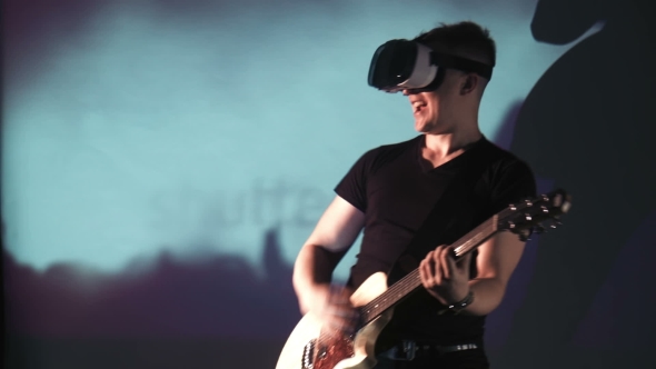 Man In VR Glasses Playing Guitar
