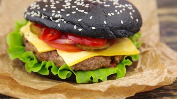 Black Burger on Wooden Table