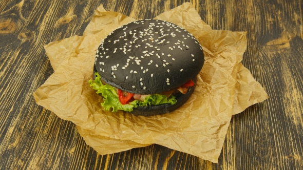 Black Burger on Wooden Table