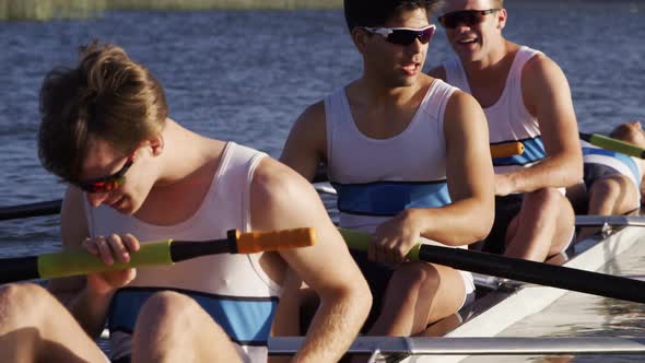 Front view of male rower team resting on the lake