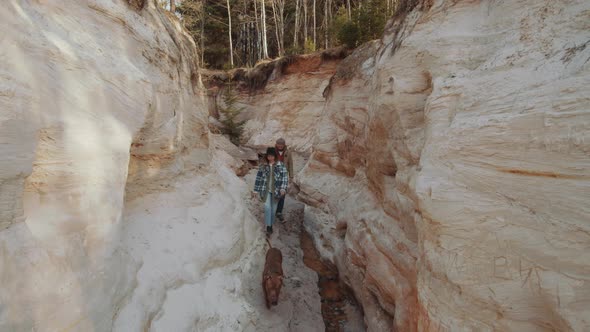 Couple Walking with Dog through Canyon