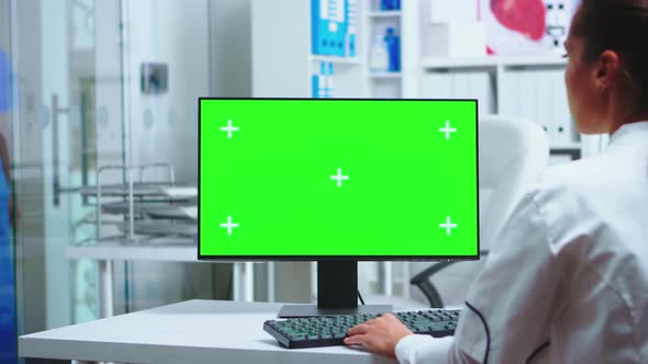 Female Doctor Working on Green Screen PC