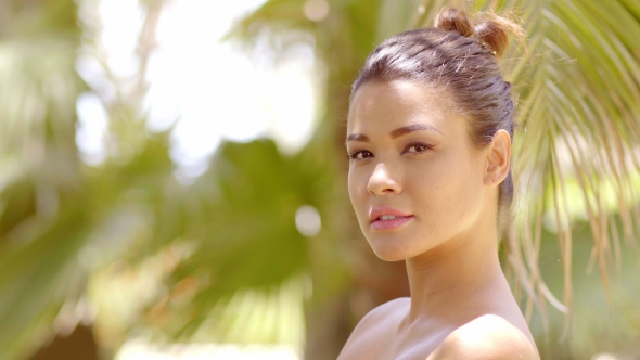 Young Woman With Bare Shoulders Near Palm Leaves