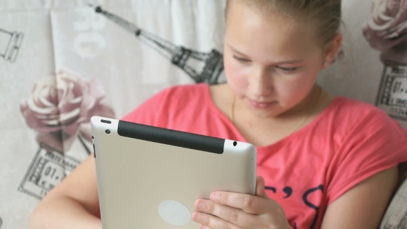 Child Lying On The Bed With a Digital Tablet