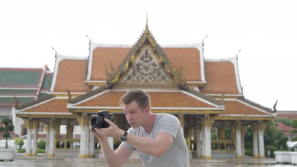 Young Happy Tourist Man Photographing Around the Buddhist Temple in Bangkok