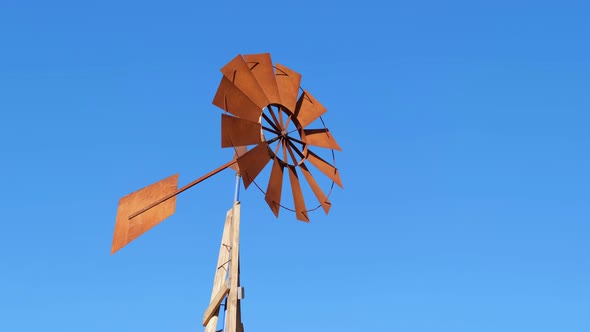 Retro Fan of a Wind Pump Moving Fast Against a Blue Sky