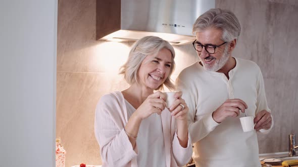 Mature couple drinking coffee in the kitchen