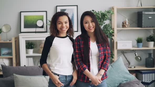 Slow Motion Portrait of Young Ladies Asian and African American Standing at Home