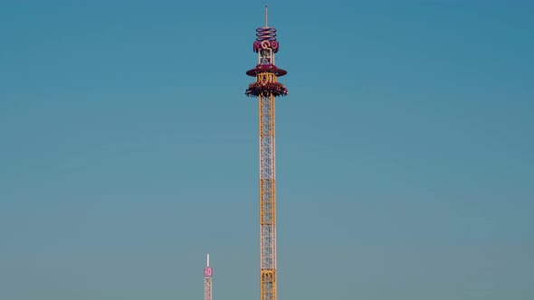 A rotating chair swing ride carousel with teenagers enjoying the ride in a amusement park.