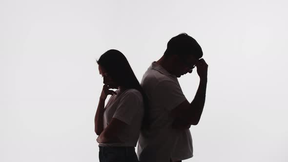 Silhouette of a married couple standing back to back, turning and looking at each other.