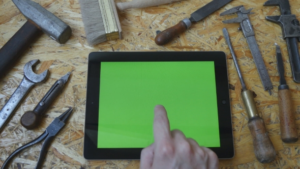Male Hand Of Artisan Craftsman Using Tablet Pc With Green Screen In Workshop.