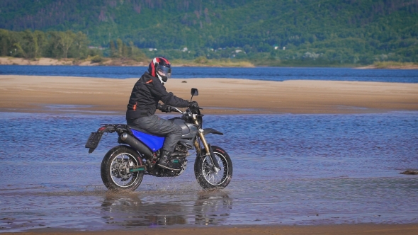 The Feeling Of Freedom And Moto Aesthetics. Motorcyclist Riding On His Bike On Sandy Beach.