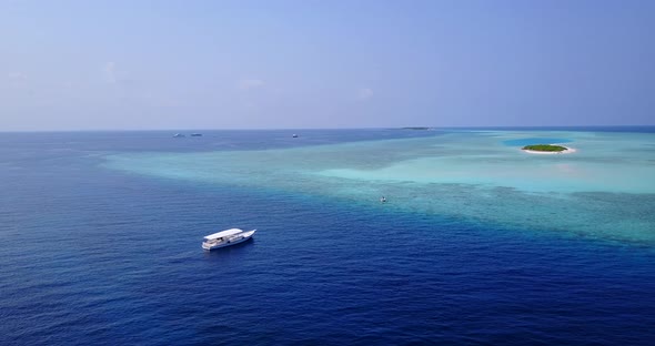 Tropical fly over tourism shot of a white sand paradise beach and aqua blue water background in colo