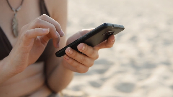  Of Girl Work At Smartphone On The Beach