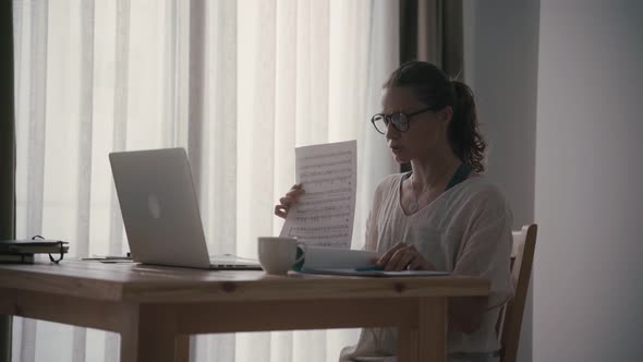 Young Woman Music Teacher Leads an Online Lesson on a Laptop