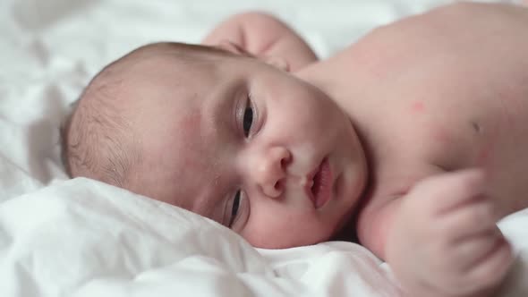 Closeup of Newborn Baby on White Blanket