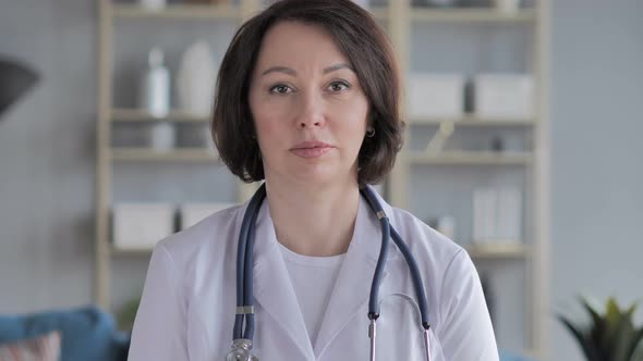 Portrait of Serious Old Lady Doctor Looking at Camera