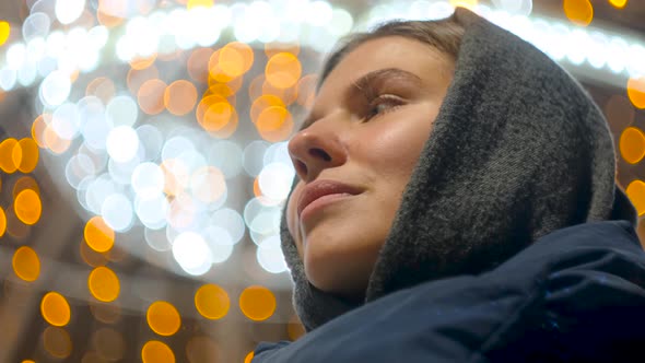 Young woman is waiting on background of garlands