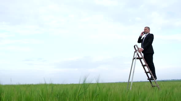 A Man is Looking for a Mobile Network in a Field