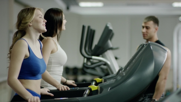 Fit Coach And Young Woman On The Treadmill