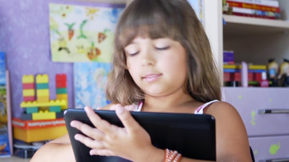 A Young Girl Is Playing a Computer Game On a Digital Tablet.