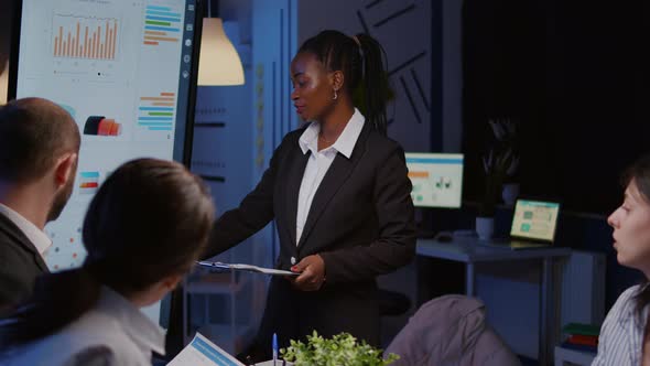 Workaholic African American Leader Standing in Front of Presentation Monitor Explaining Marketing