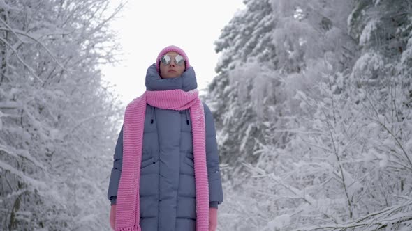 Traveler Woman in Pink Clothes a Scarf and a Hat and Sunglasses is Walking