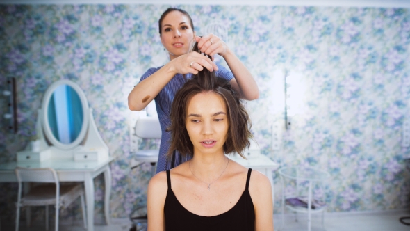 In The Professional Salon Haircuts, The Master Makes Hair Styling For a Young Girl.