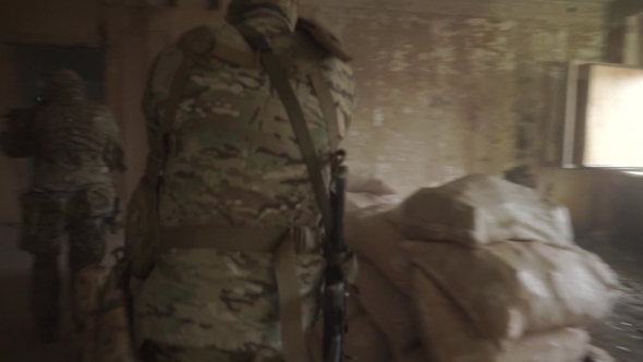 Armed Soldiers Quietly Advance In a Hostile Ruined Building alt