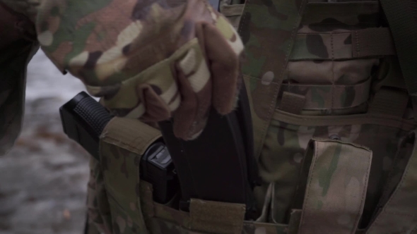 Soldier Puts Assault Rifle Ammo Into Pockets Of His Ammo Vest