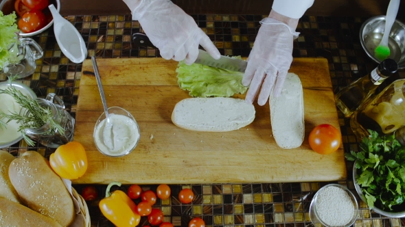 Chef Puts Salad Leaf on a Sandwich