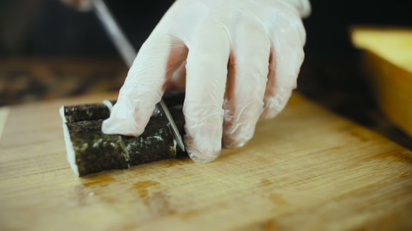 Chef Cuts Sushi On Wooden Board