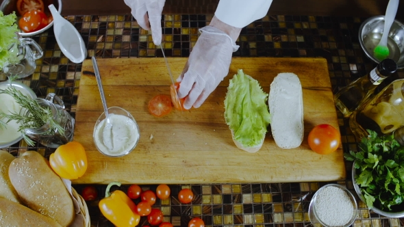 Chef Cuts And Puts Tomatoes On The Sandwich