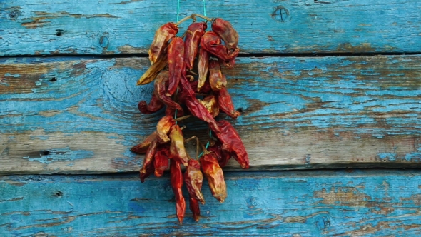 Footage Men Hangs Dried Red Pepper On a Wooden Wall