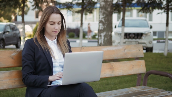 Young Beautiful Business Woman Using Laptop PC Sitting On Bench Outdoors