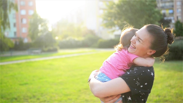 Mother And Child Are Hugging And Having Fun Outdoor In Nature, Happy Cheerful Family. Mother And