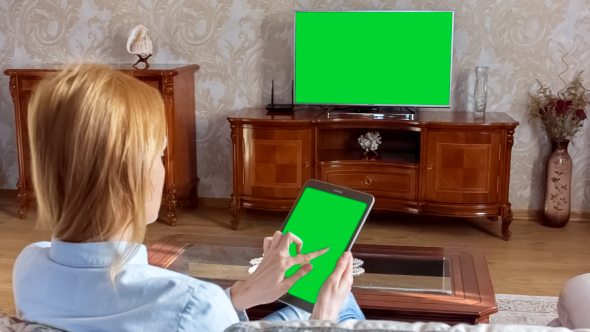 Girl Using Tablet In Front Of The TV 1 With Green Screen