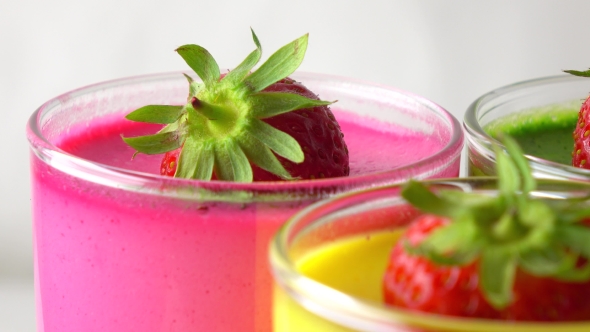 Pink, Yellow And Green Pannacotta Desserts With Strawberries  