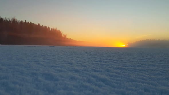 Time lapse of beautiful frozen lake in Finland filled with mist fog during sunset, dreamlike moment