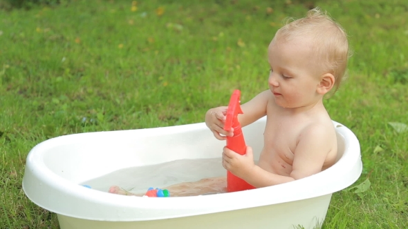 One Year Old Kid Having a Bath Outdoors