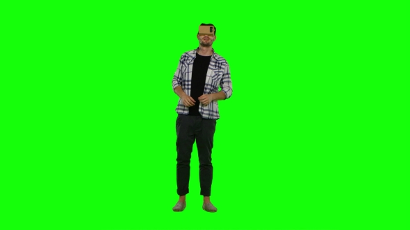Young Man Trying Virtual Reality Glasses - VR Glasses - And Exploring Virtual Reality. Green Screen